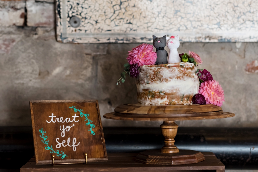 A wedding cake with cats on top and a sign that says treat yo self.